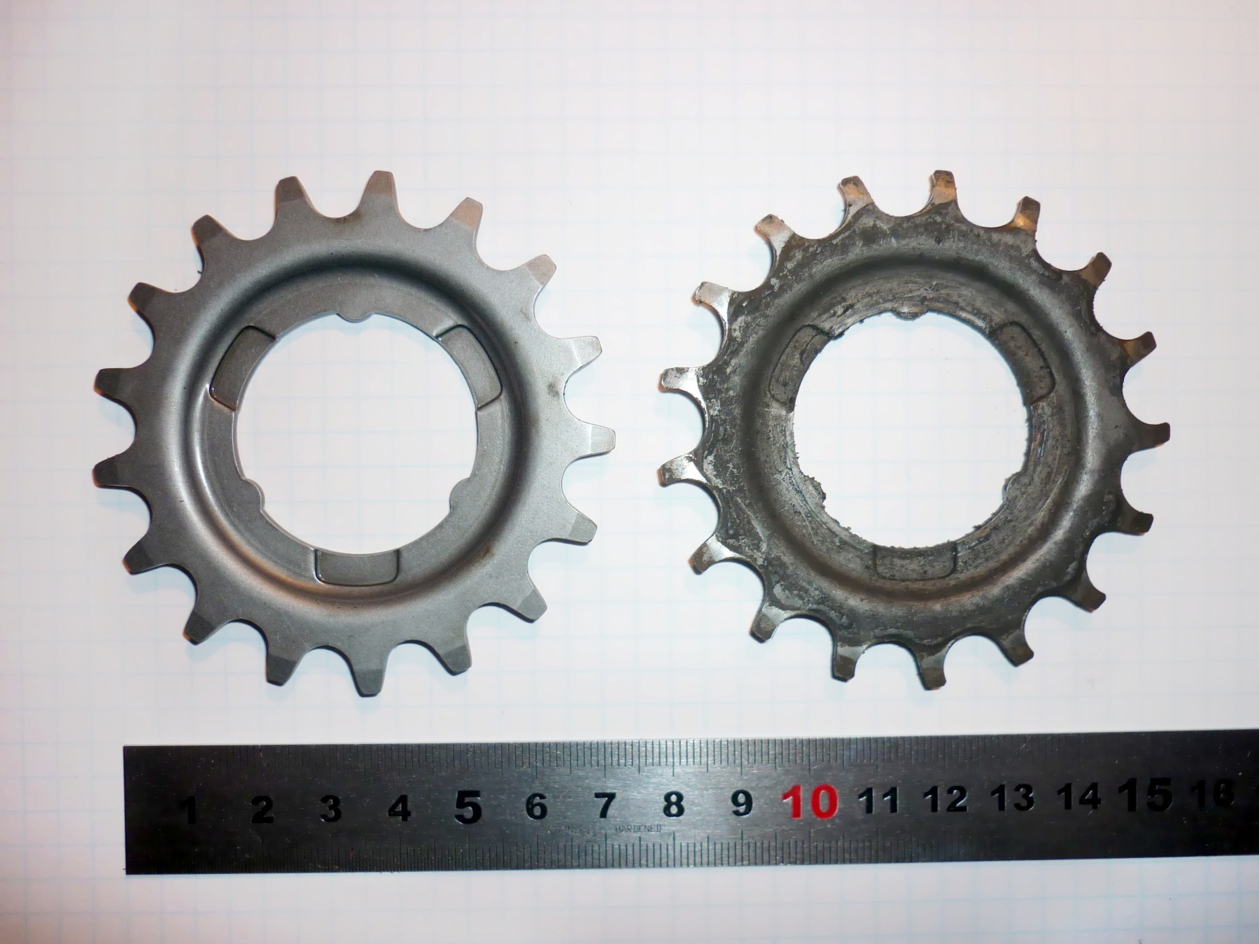 An unused rear sprocket beside a worn sprocket with visibly changed tooth profiles